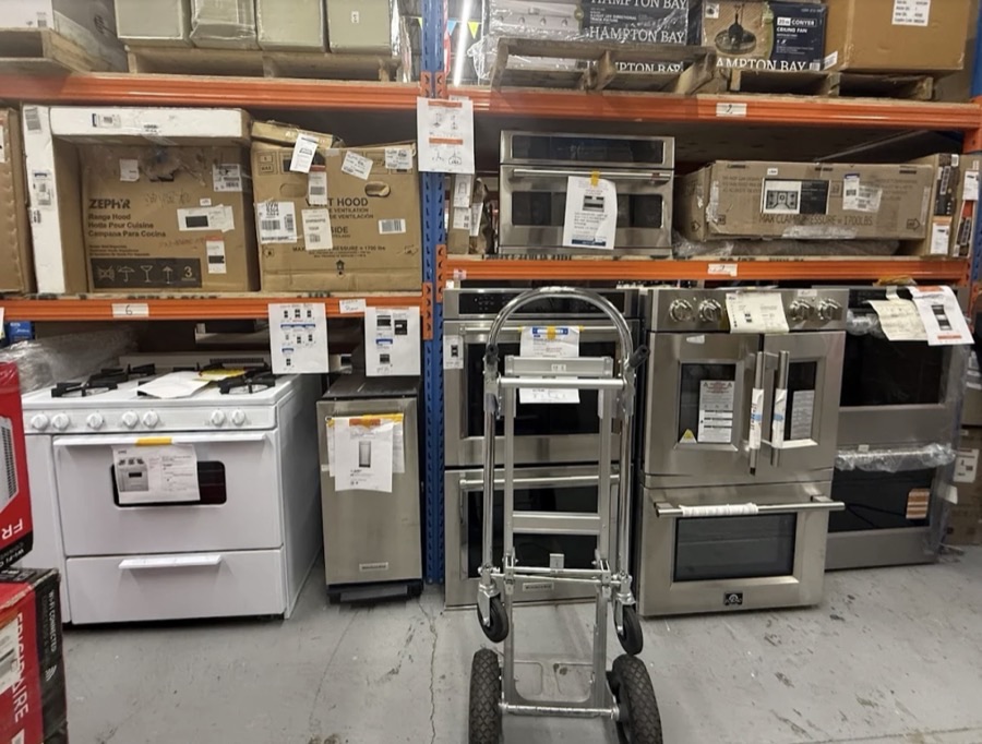 Row of new and open-box appliances including ranges, microwaves, and dishwashers