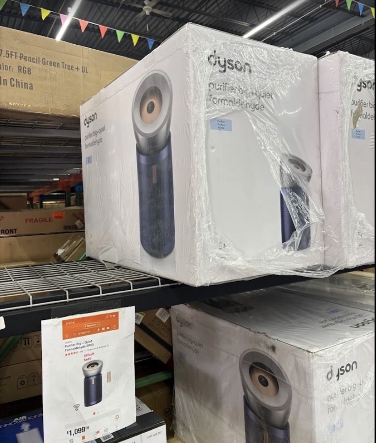 Stack of Dyson vacuums and air purifiers in original packaging