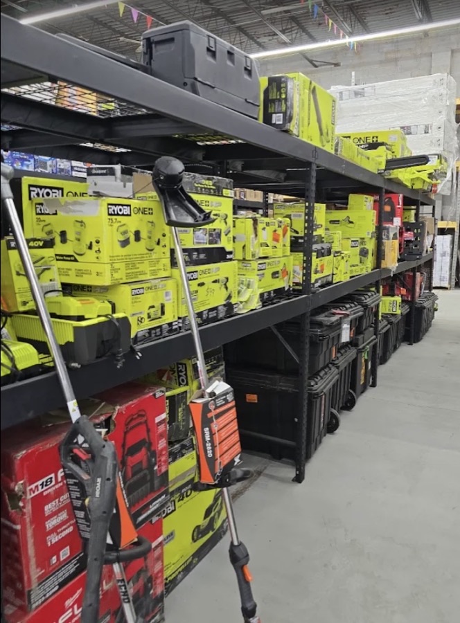 Shelves stocked with Ryobi power tools, drills, and lawn equipment