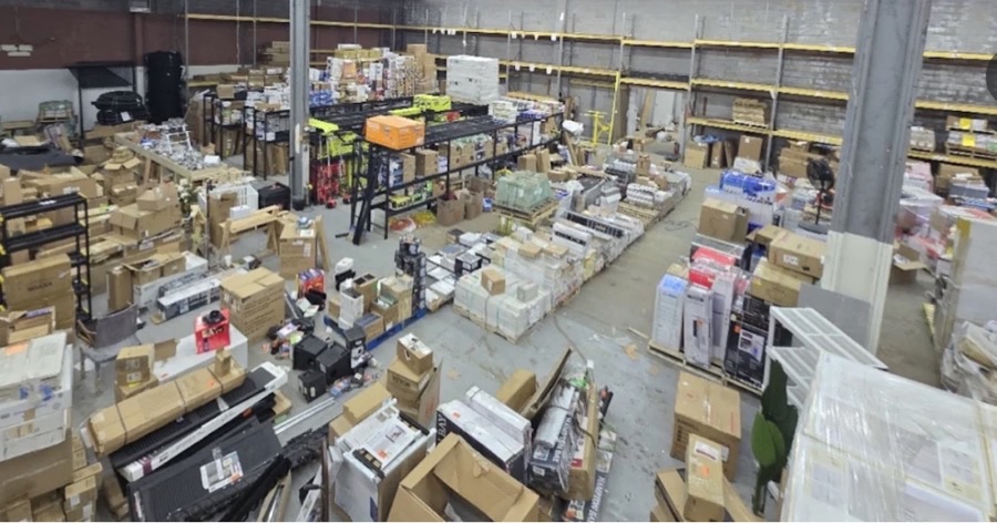 Aerial view of ABC Home Outlet warehouse interior with pallets, shelves, and forklift